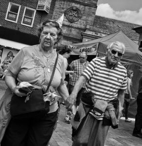 Black and white street photography of an older couple.