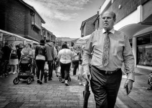 Street photography of a man walking down a street.