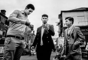 Black and white street photography of three men in suits.