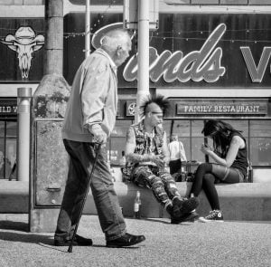 A street photography snapshot featuring a group of people sitting on a bench.