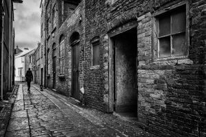 A black and white street photography of a narrow alley.