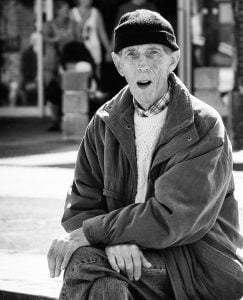 Street photography of an elderly man on a bench.