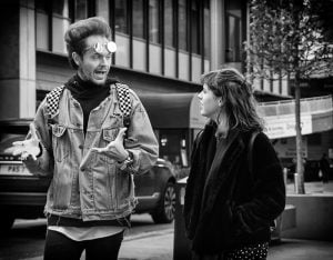 Street photography featuring a man and woman engaged in conversation.