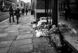 Street photography of homeless individuals in black and white.