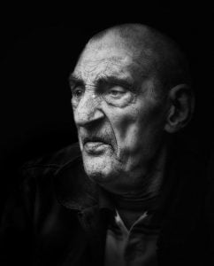 A black and white street photography portrait of an old man.