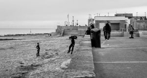 A black and white photo of a group of people on the beach in Rhyl.