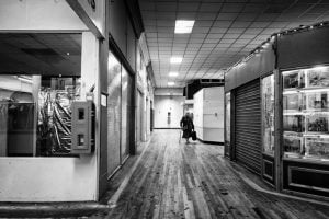 A black and white photo of a hallway with a person walking down it in Rhyl.