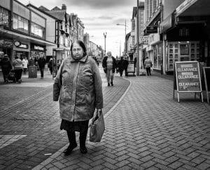 A woman walking down a Rhyl street in black and white.