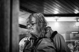 A black and white photo of a woman with glasses in Rhyl.