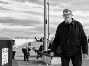 Street photography - Black and white photograph of a man near a trash can.